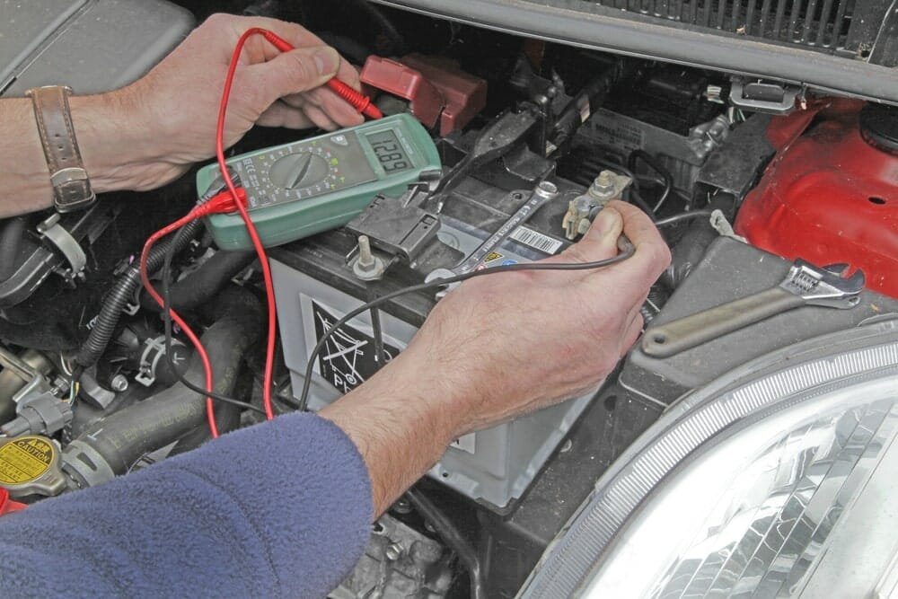	Multimeter probe on a chassis ground bolt and the other probe on the battery negative terminal testing ground connection voltage
